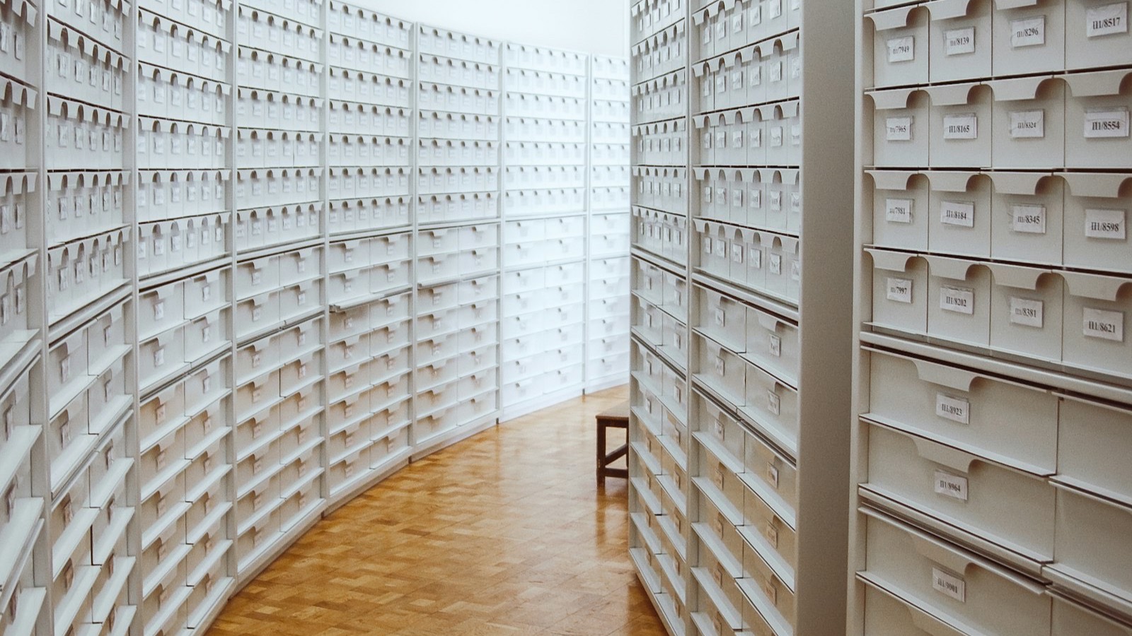 An aisle of white records shelving in a public archive.